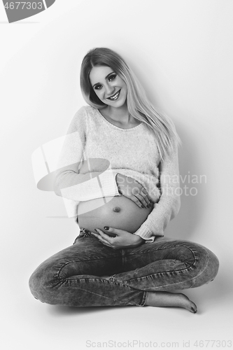 Image of Beautiful pregnant woman in jeans