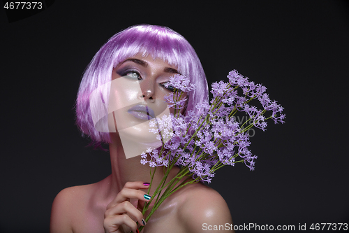 Image of Beautiful girl in purple wig with flowers