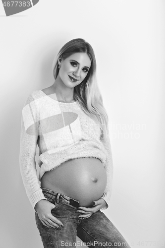 Image of Beautiful pregnant woman in jeans