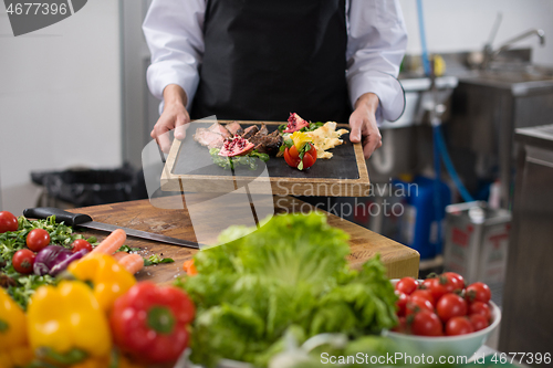 Image of female Chef holding beef steak plate