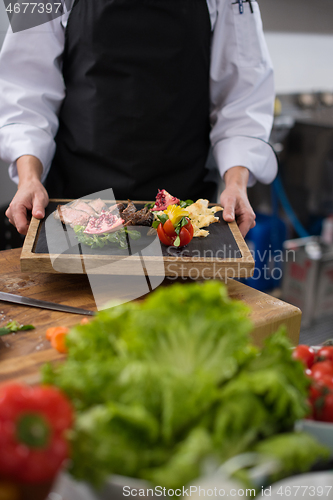 Image of female Chef holding beef steak plate