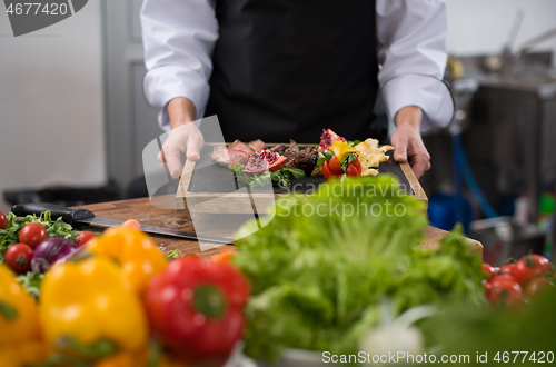 Image of female Chef holding beef steak plate