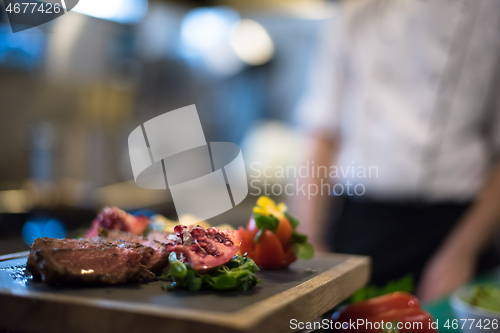 Image of Juicy slices of grilled steak on wooden board