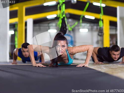 Image of young healthy people doing pushups