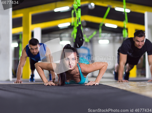 Image of young healthy people doing pushups