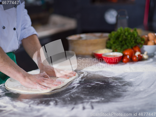 Image of chef preparing dough for pizza