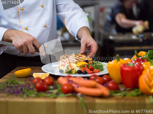 Image of cook chef decorating garnishing prepared meal