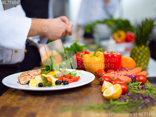 Image of cook chef decorating garnishing prepared meal