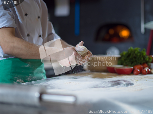 Image of chef hands preparing dough for pizza