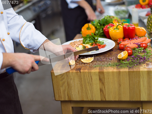 Image of cook chef decorating garnishing prepared meal