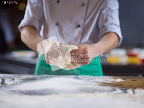 Image of chef hands preparing dough for pizza