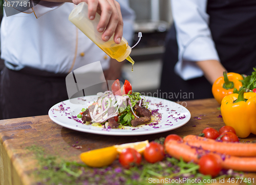 Image of Chef finishing steak meat plate