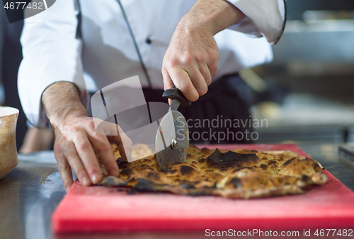 Image of chef cutting baked bread