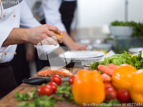 Image of Chef hands preparing marinated Salmon fish