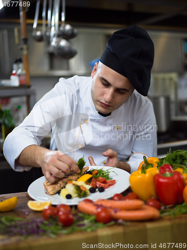 Image of cook chef decorating garnishing prepared meal