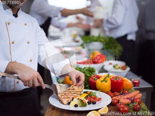 Image of cook chef decorating garnishing prepared meal