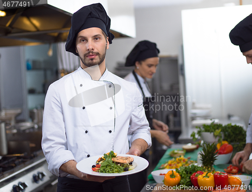 Image of Chef holding dish of fried Salmon fish fillet