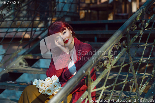 Image of Girl sitting on old house stairs