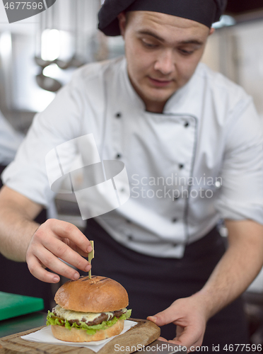 Image of chef finishing burger