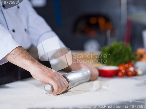 Image of chef preparing dough for pizza with rolling pin