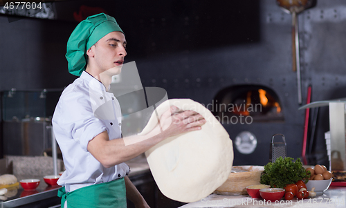 Image of chef throwing up pizza dough