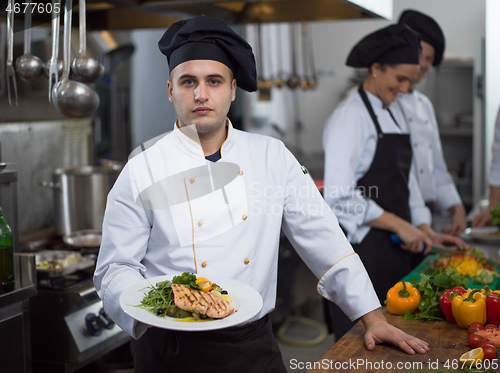 Image of Chef holding dish of fried Salmon fish fillet