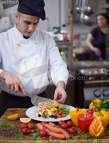 Image of cook chef decorating garnishing prepared meal