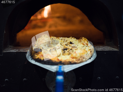 Image of chef removing hot pizza from stove