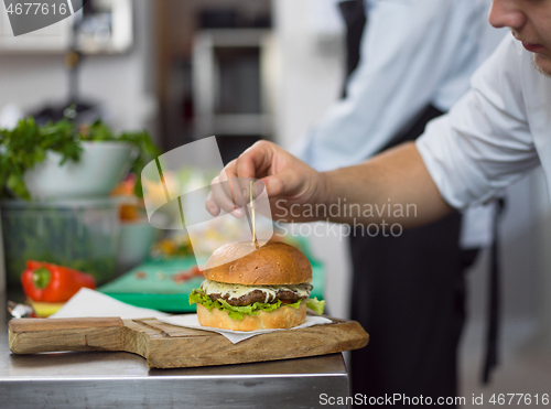 Image of chef finishing burger