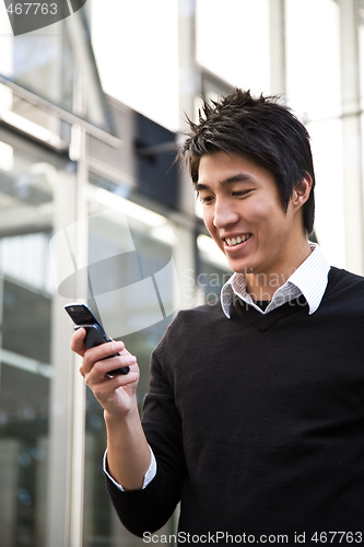 Image of Texting casual asian businessman