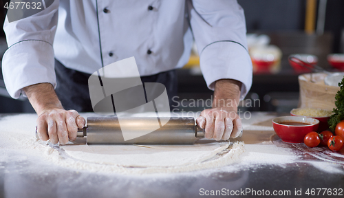 Image of chef preparing dough for pizza with rolling pin