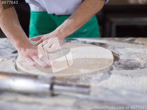 Image of chef preparing dough for pizza