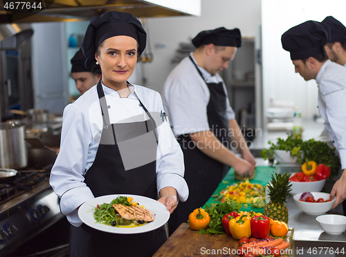 Image of Chef holding dish of fried Salmon fish fillet