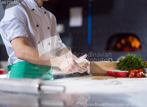 Image of chef hands preparing dough for pizza