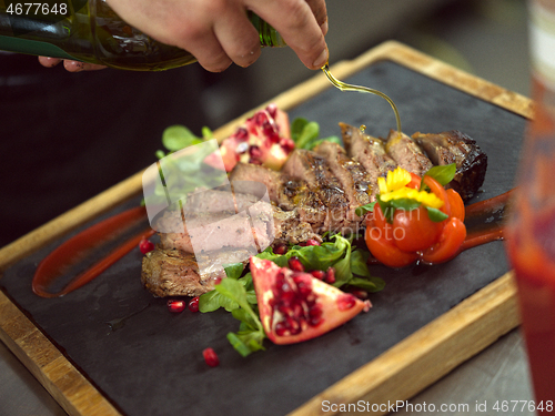 Image of Chef finishing steak meat plate