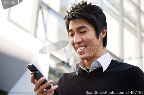 Image of Casual asian businessman texting