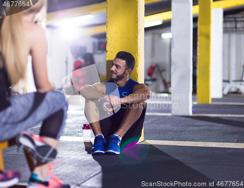 Image of young athletes sitting on the floor and relaxing