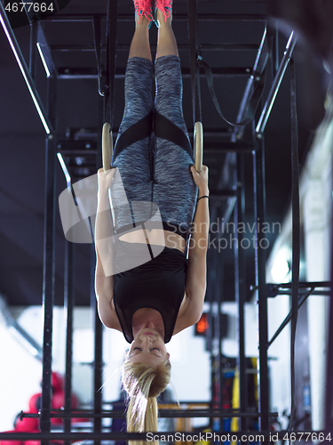 Image of woman working out with personal trainer on gymnastic rings