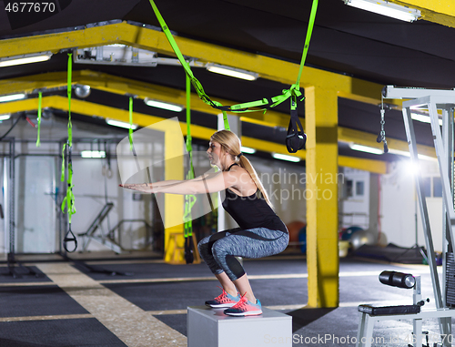 Image of woman working out  jumping on fit box