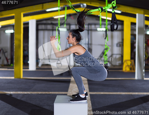 Image of woman working out  jumping on fit box