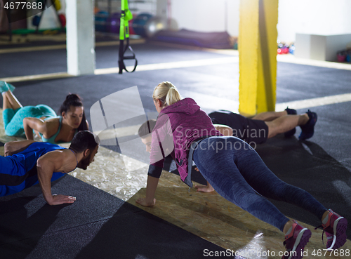 Image of young healthy people doing pushups