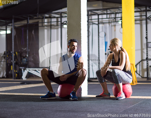 Image of young athletes sitting on the crossfitness ball and relaxing