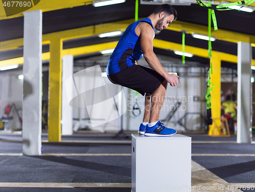 Image of man working out jumping on fit box