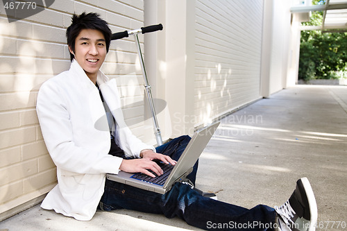 Image of Young casual asian male with laptop