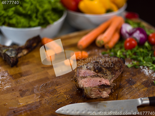 Image of Juicy slices of grilled steak on wooden board