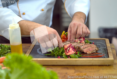 Image of closeup of Chef hands serving beef steak