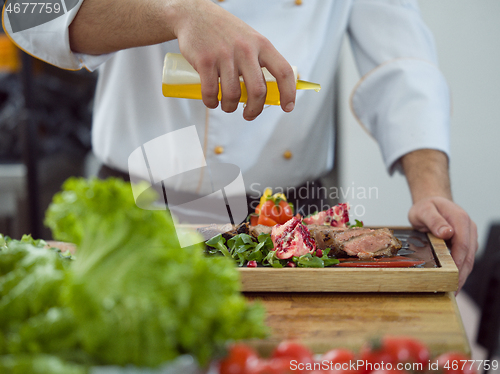 Image of Chef finishing steak meat plate