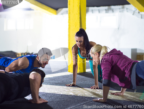 Image of young healthy people doing pushups