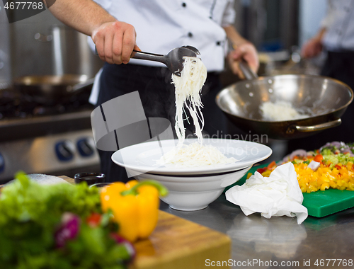 Image of Chef hands serving spaghetti