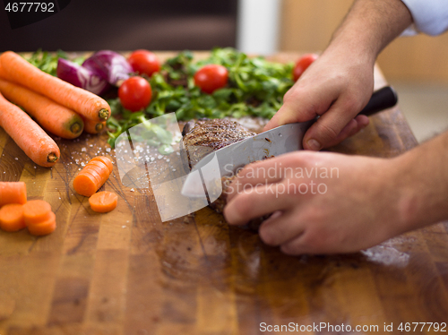 Image of closeup of Chef hands preparing beef steak